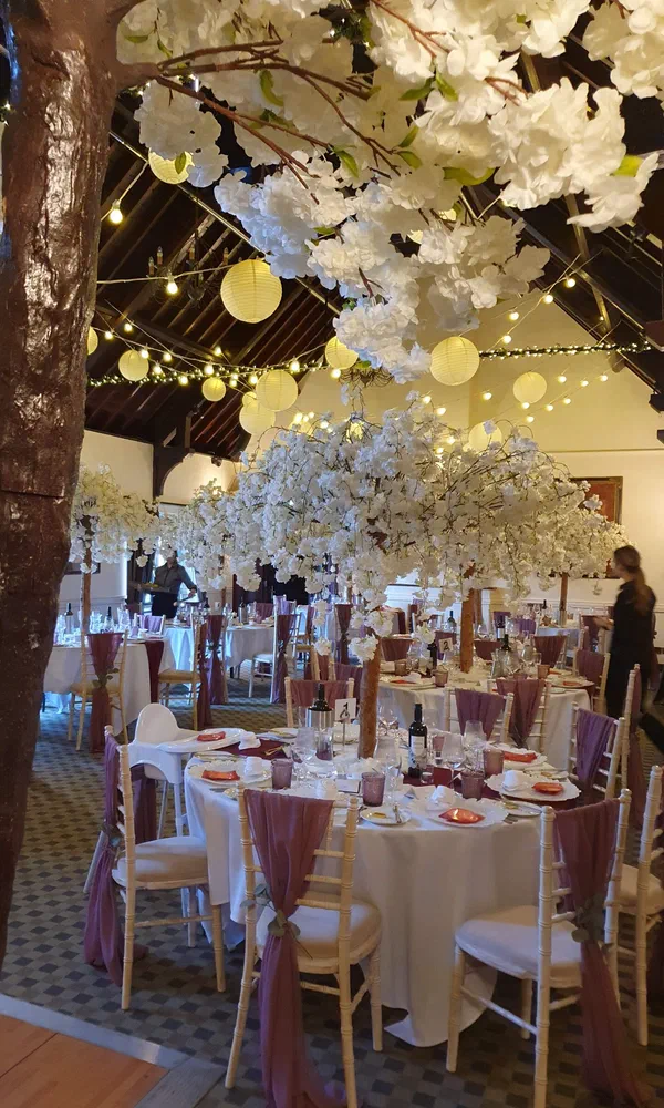 Barn venue decorated with white cherry blossom trees