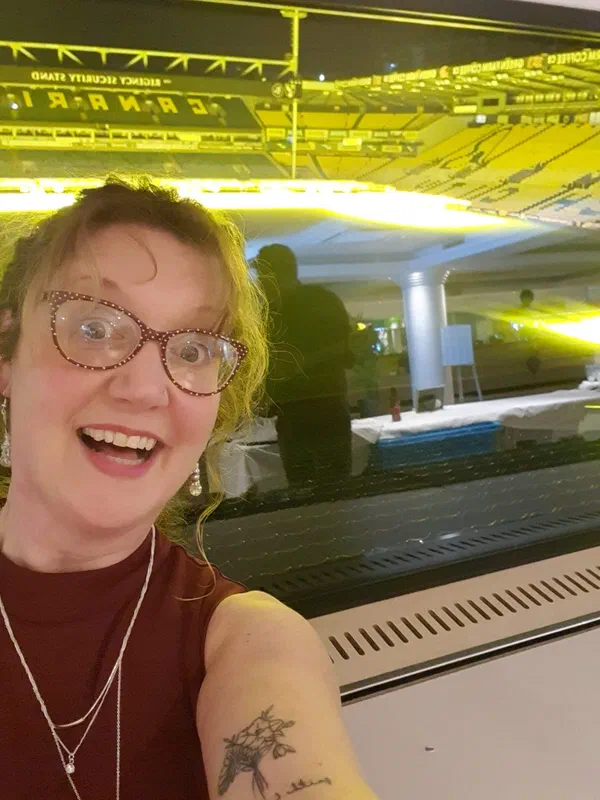 Sarah at soundcheck in a venue with festoon lighting