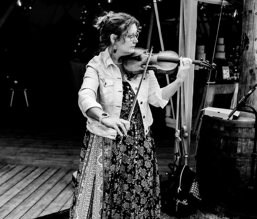 Sarah performing violin at an outdoor tipi wedding, black and white